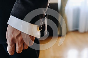 Close-up of a man& x27;s hands in a black formal suit with cuffs