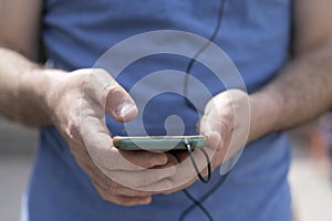 Close-up of a man`s hands holding his phone