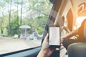 Close-up of man`s hands holding smartphone in the car interior,