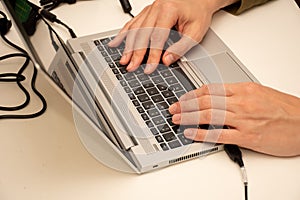 Close up of man`s hands on a laptop keyboard