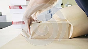 Close up man`s hands packing boxes of sellotape in printing industry