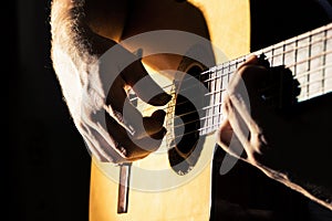 Close up of man`s hands playing classical guitar. Musical instrument for recreation or hobby passion concept