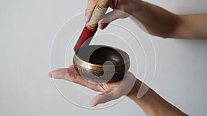 Close up of a man`s hands playing a tibetan singing bowl