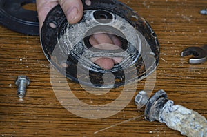 Close-up of a man`s hands showing a torn rubber gasket for a water heater