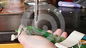 Close up of man`s hands soldering microswitch electrical card using slodering iron.