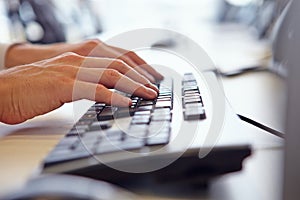 Close up of man?s hands using the keyboard of a computer photo