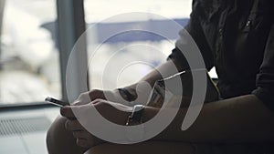 Close up of Man`s hands using mobile smartphone in airport