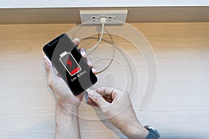 Close up man\'s hands using smart phone battery low charge battery screen, Businessman holding a smartphone Low battery photo