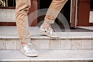 Close up of man's legs in keds going down stairs.