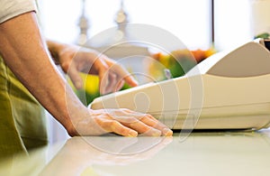 Close up of man or seller at flower shop cashbox