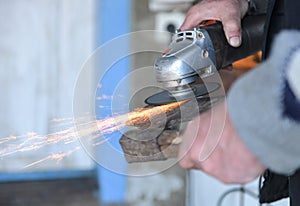 Close up of a man sharpen an ax using electric grinder