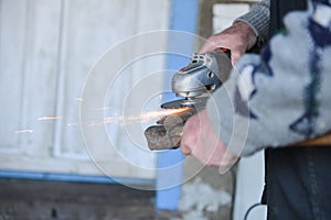 Close up of a man sharpen an ax using electric grinder