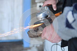 Close up of a man sharpen an ax using electric grinder