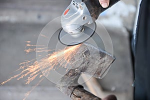 Close up of a man sharpen an ax using electric grinder