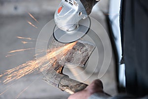 Close up of a man sharpen an ax using electric grinder