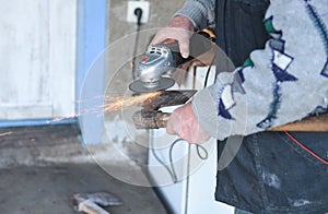 Close up of a man sharpen an ax using electric grinder