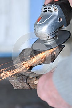 Close up of a man sharpen an ax using electric grinder