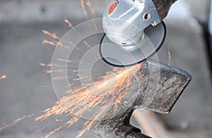 Close up of a man sharpen an ax using electric grinder photo