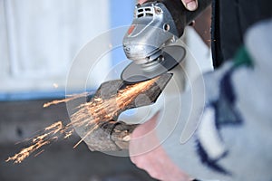 Close up of a man sharpen an ax using electric grinder photo