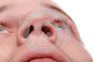 Close-up of a man showing his nostrils. Isolated over white background