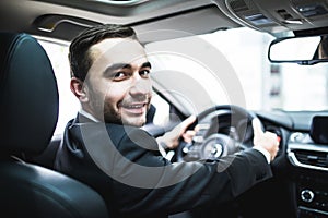 Close up of man sitting in cabriolet car at auto show or salon