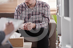 Close-up of a man sitting on a couch during marital consultation