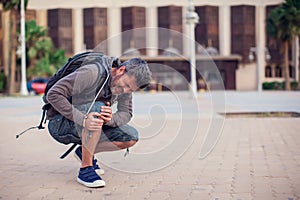 Close up of a man sitting and holding his knee in pain due to injury outdoor. People, health care and medical concept