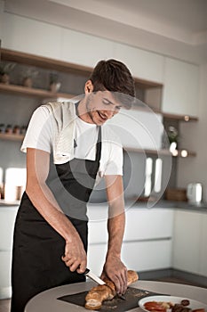 Close up. man slicing bread for sandwiches