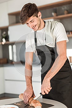 Close up. man slicing bread for sandwiches