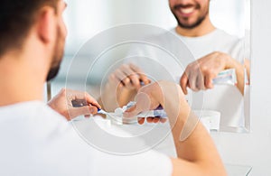 Close up of man squeezing toothpaste on toothbrush