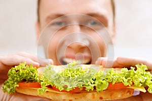 Close up of man taking bite sandwich