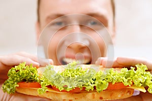 Close up of man taking bite sandwich photo