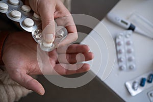 Close-up of a man taking pills from a blister. Flu and cold treatment disease concept