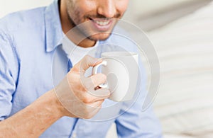 Close up of man with tea or coffee cup at home