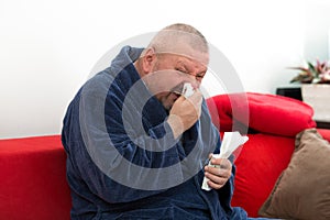 Close-up of a man with tissue in his nose.