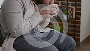 Close up of man trembling and holding cup of coffee at aa therapy meeting