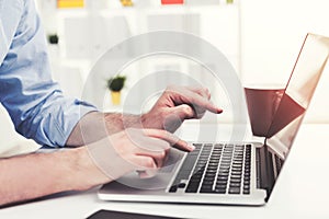 Close up of man typing at laptop