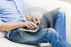 Close up of man typing on laptop computer at home