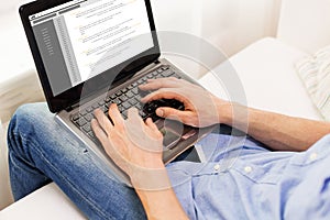 Close up of man typing on laptop computer at home