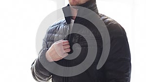 Close up of man unzipping his black jacket at home