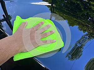 Close up man use soft towel to clean black car