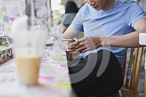 Close up of man using mobile phone in a cafe
