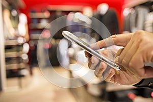 Close up of a man using mobile phone in clothing store