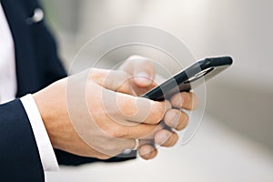 Close up of a man using mobile smart phone. Businessman working on the smartphone