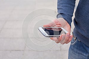 Close up of a man using mobile smart phone outdoor.