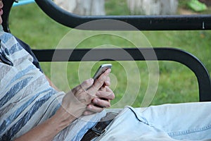 Close up of a man using mobile smart phone sitting outdoors. Business concept