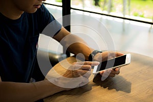 Close up of a man using mobile smart phone on the table.