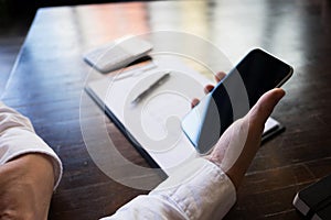 Close up of a man using mobile smart phone on the table