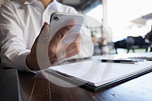 Close up of a man using mobile smart phone on the table