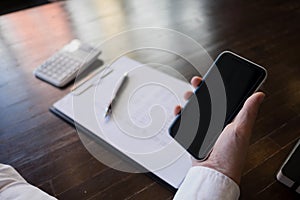 Close up of a man using mobile smart phone on the table